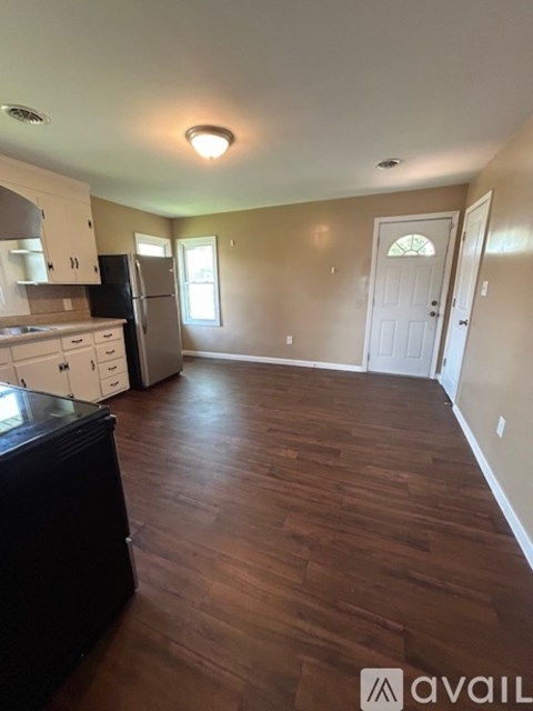 A kitchen with dark wood floors and white appliances.