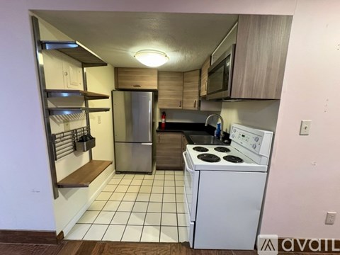 A kitchen with white appliances and a white stove.