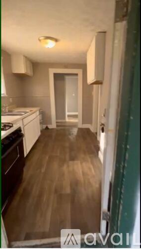 A kitchen with wooden floors and white appliances.