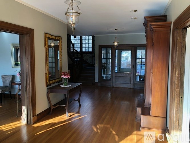 A large room with wooden floors and a chandelier hanging from the ceiling.