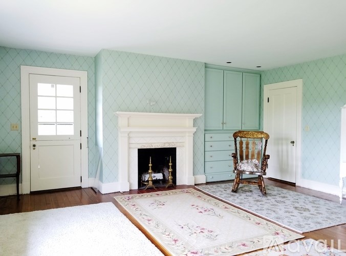 A living room with wooden floors and a high ceiling.