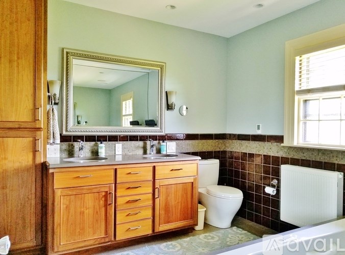 A white house with a black roof and a chimney.