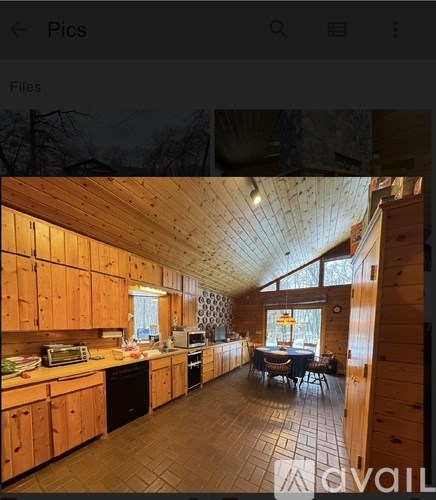 A well-lit kitchen with wooden cabinets and a dining table.
