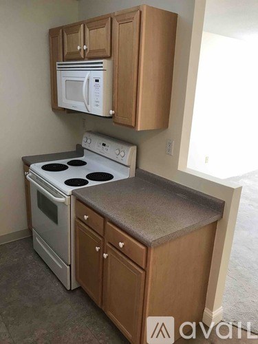 A kitchen with a white microwave and stove top oven.