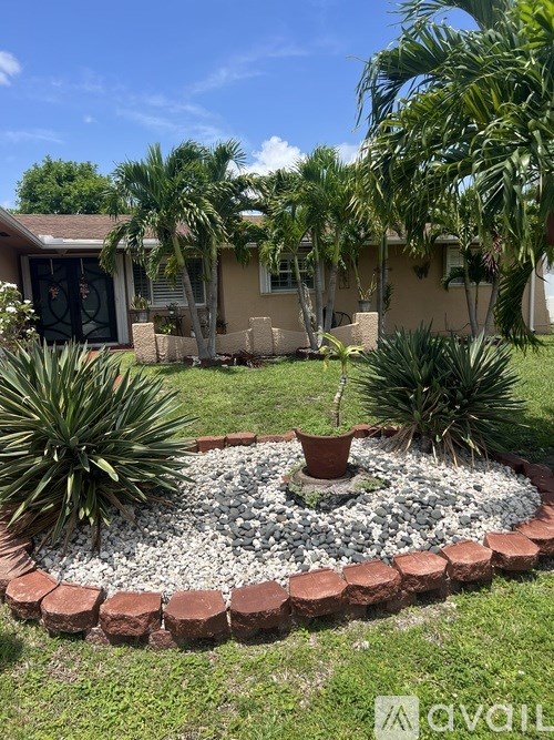 A garden with a circular brick border and a potted plant in the center.