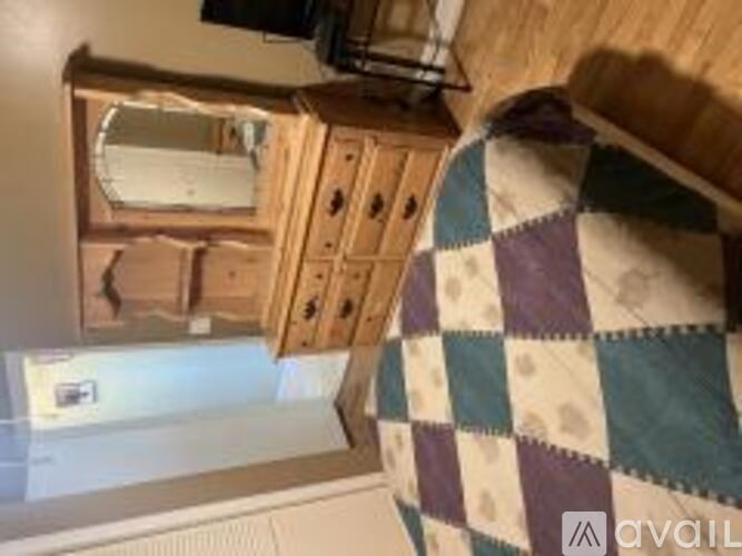 A quilt with a checkered pattern is draped over a chair.