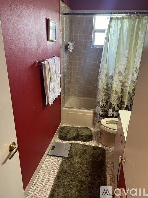 A bathroom with a red wall and a white door.