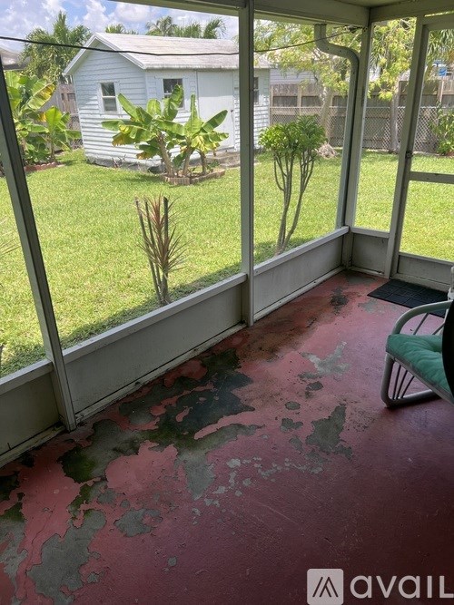 A sunny day in a backyard with a white house and a green chair.