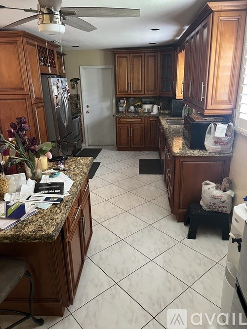 A kitchen with wooden cabinets and a granite countertop.