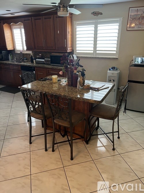 A kitchen with a table and chairs in the foreground.