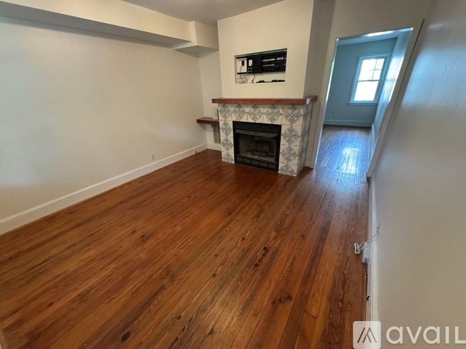A room with wooden floors and a fireplace.