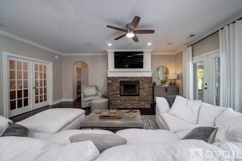 A living room with a white couch and a fireplace.