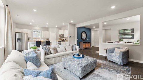 A modern living room with a white sofa and a grey ottoman.