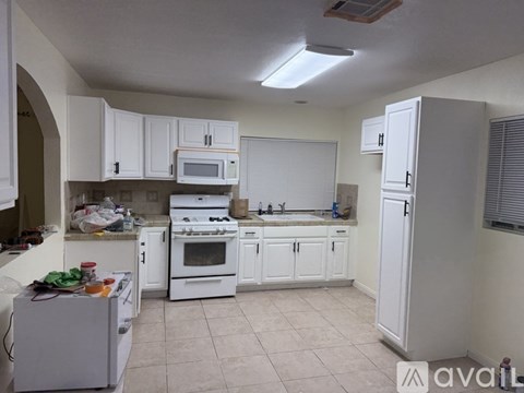 A kitchen with white cabinets and appliances.