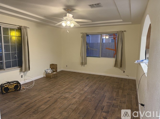 A room with wooden flooring and a ceiling fan.