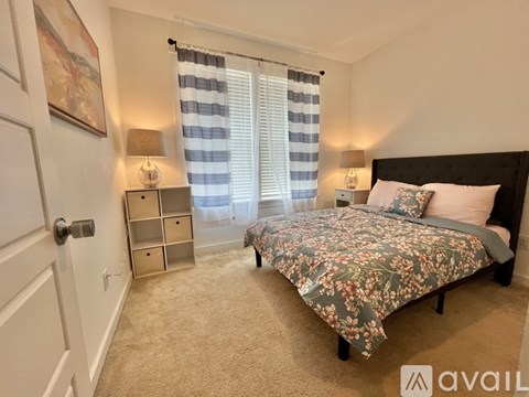 A bedroom with a large bed and a nightstand with a lamp.
