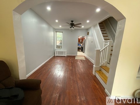 A living room with a brown couch and a ceiling fan.