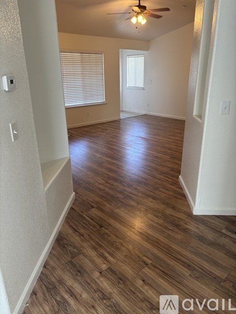 A room with wooden flooring and a ceiling fan.