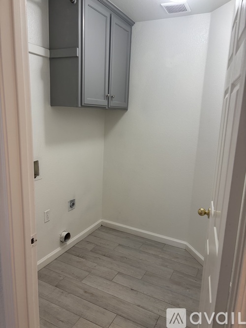 A small room with a door and a cabinet.