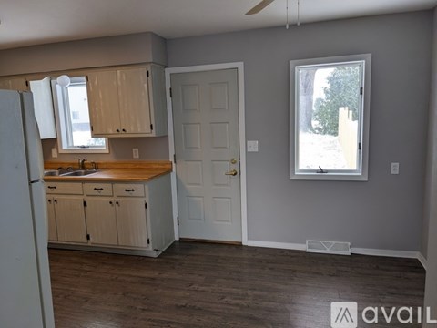 A kitchen with wooden cabinets and a white door.