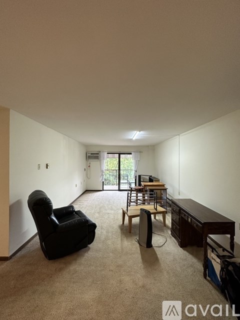 A living room with a black leather chair and a wooden table.