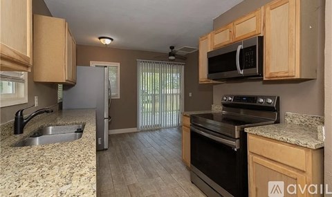 A kitchen with a sink, stove, and refrigerator.