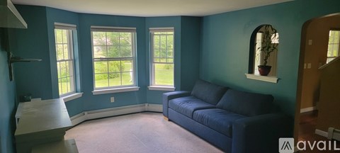 A living room with a couch and a window.