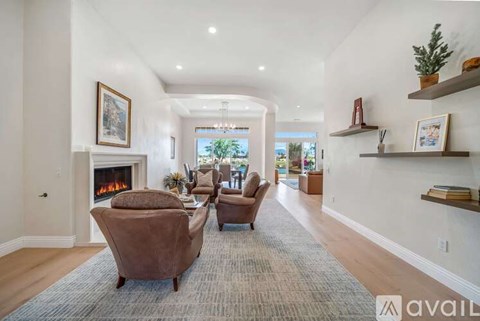 A living room with a fireplace and a carpet on the floor.