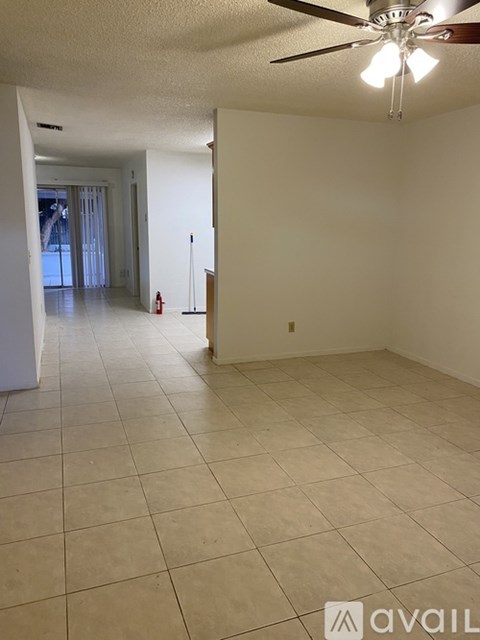 A spacious room with a ceiling fan and tiled flooring.