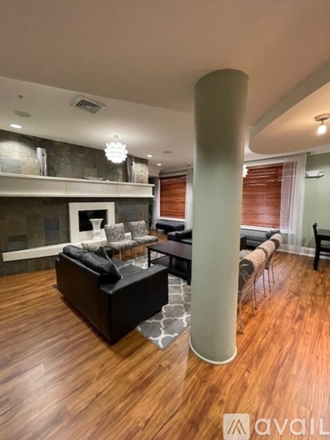A living room with a black couch and a white pillar.