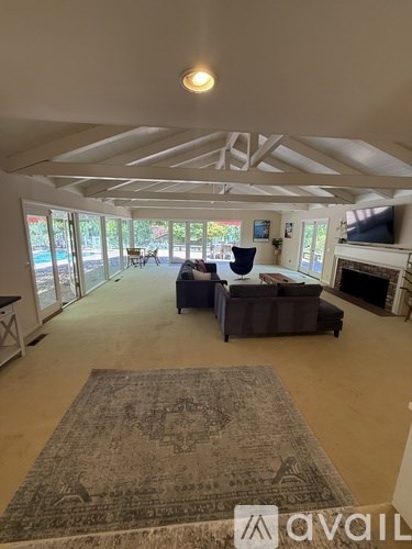 A living room with a couch, a rug, and a fireplace.