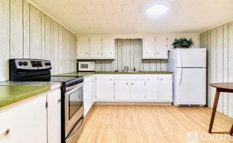 A kitchen with white cabinets and a black stove top oven.