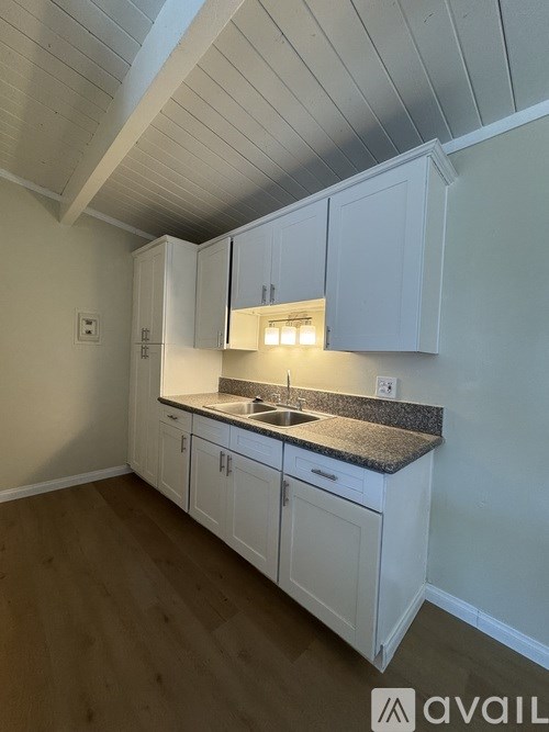 A kitchen with white cabinets and a granite countertop.