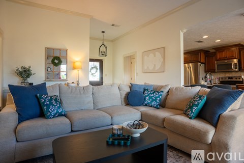 A living room with a grey couch and blue pillows.