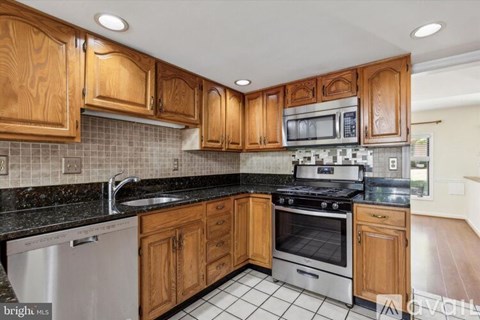 A kitchen with wooden cabinets and a black countertop.