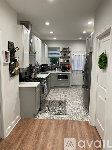 A kitchen with white cabinets and a black and white tiled floor.
