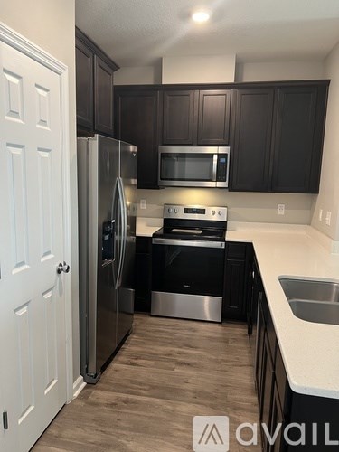 A kitchen with dark brown cabinets and a white door.