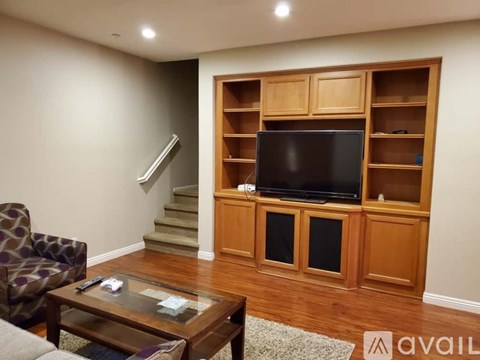 A living room with a television and a glass coffee table.