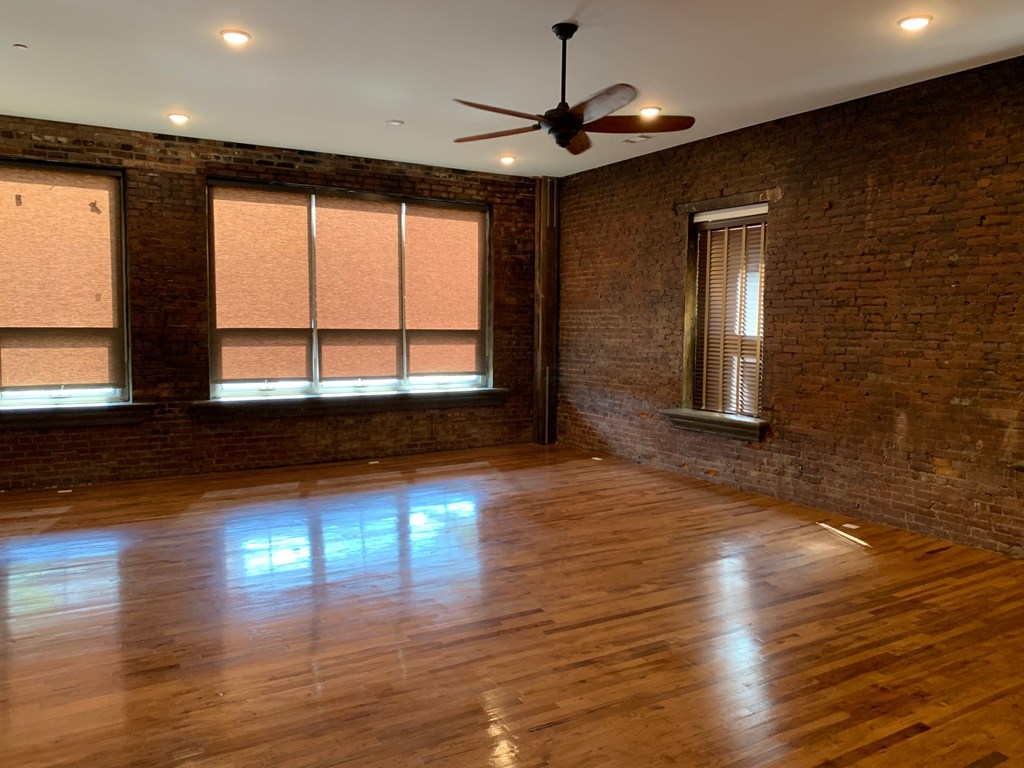 A room with wooden floors and a ceiling fan.