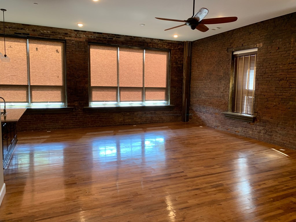 A room with wooden floors and a ceiling fan.