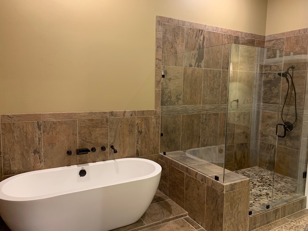 A bathroom with a white bathtub and a walk-in shower.