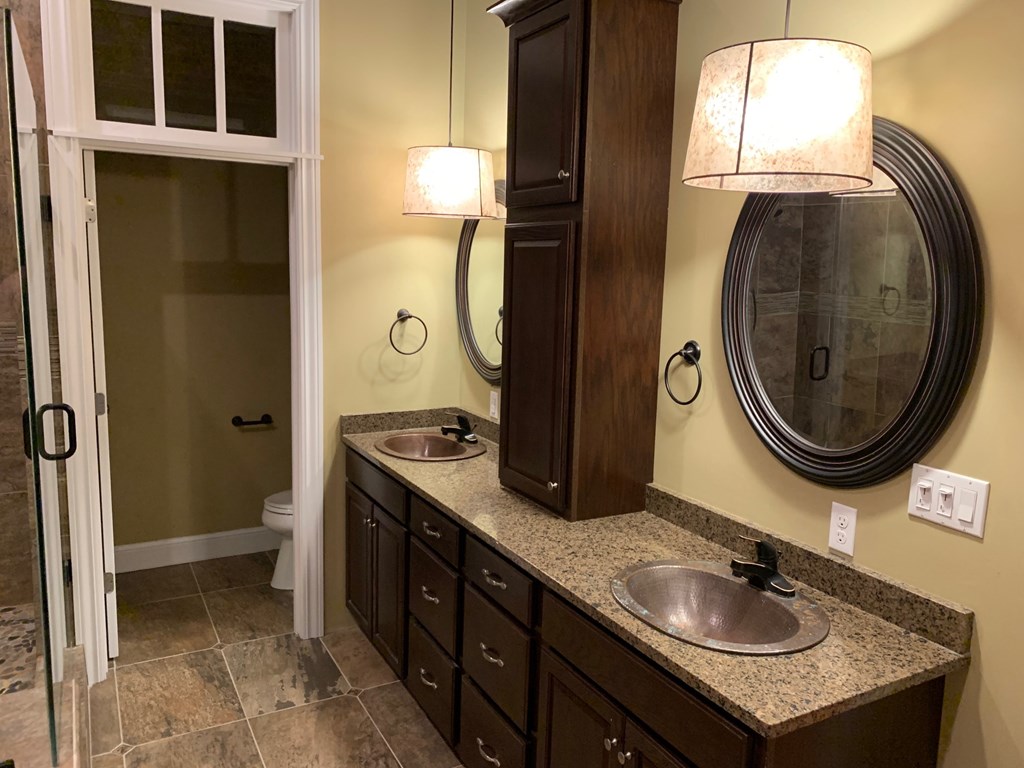 A bathroom with a sink, mirror, and a light.