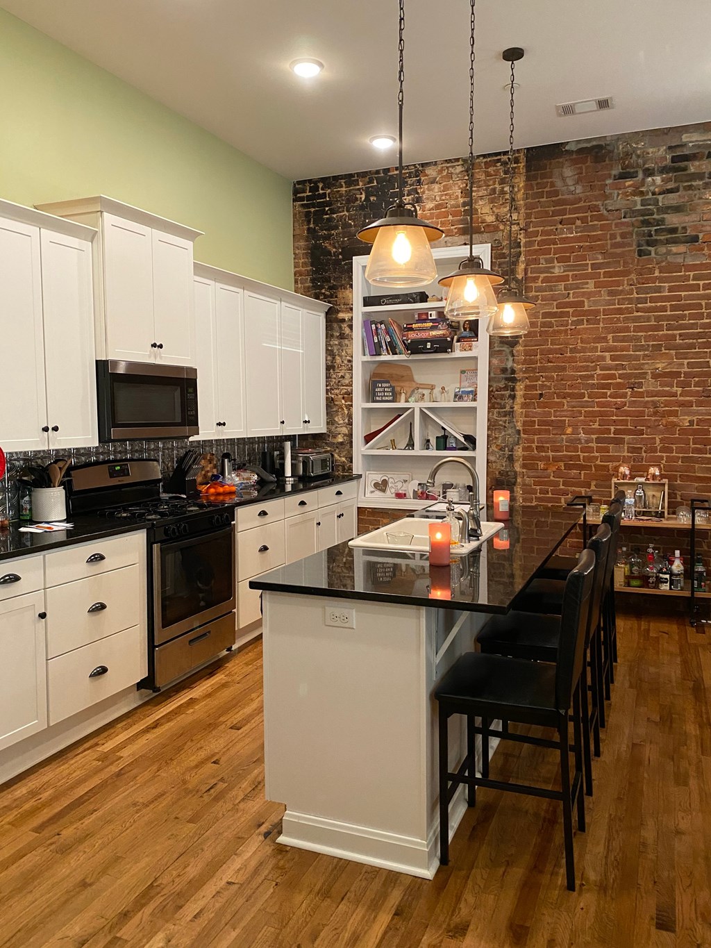 A kitchen with white cabinets and a black countertop.