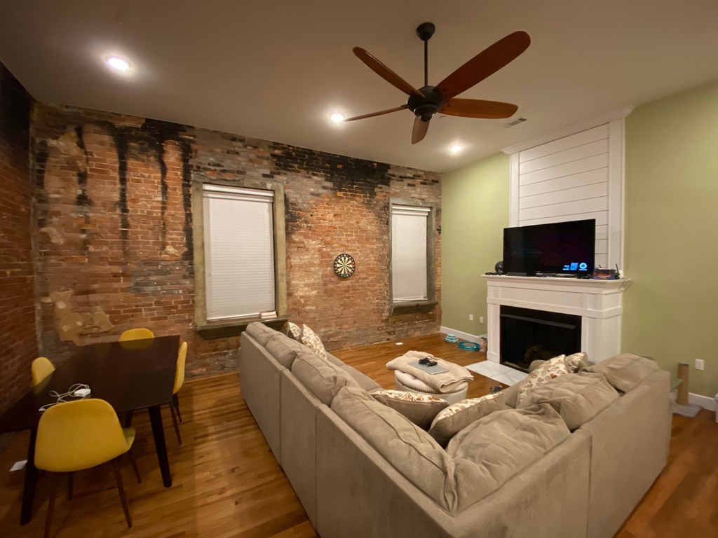 A living room with a couch, a fireplace, and a television.