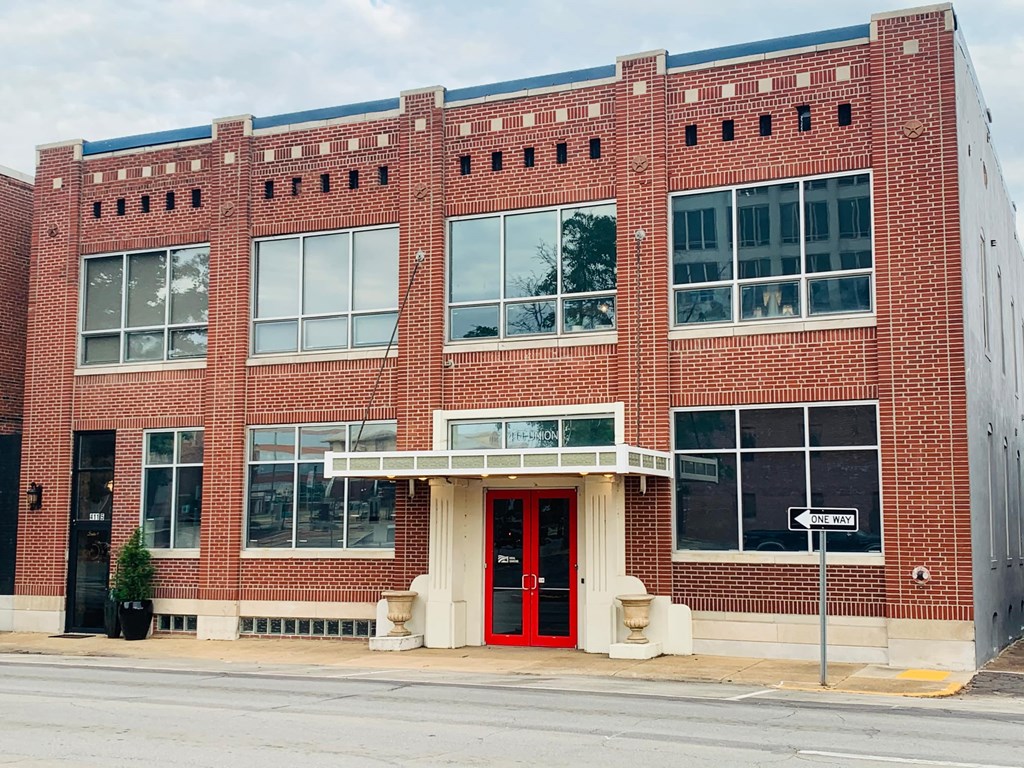 A red brick building with a black door and windows.