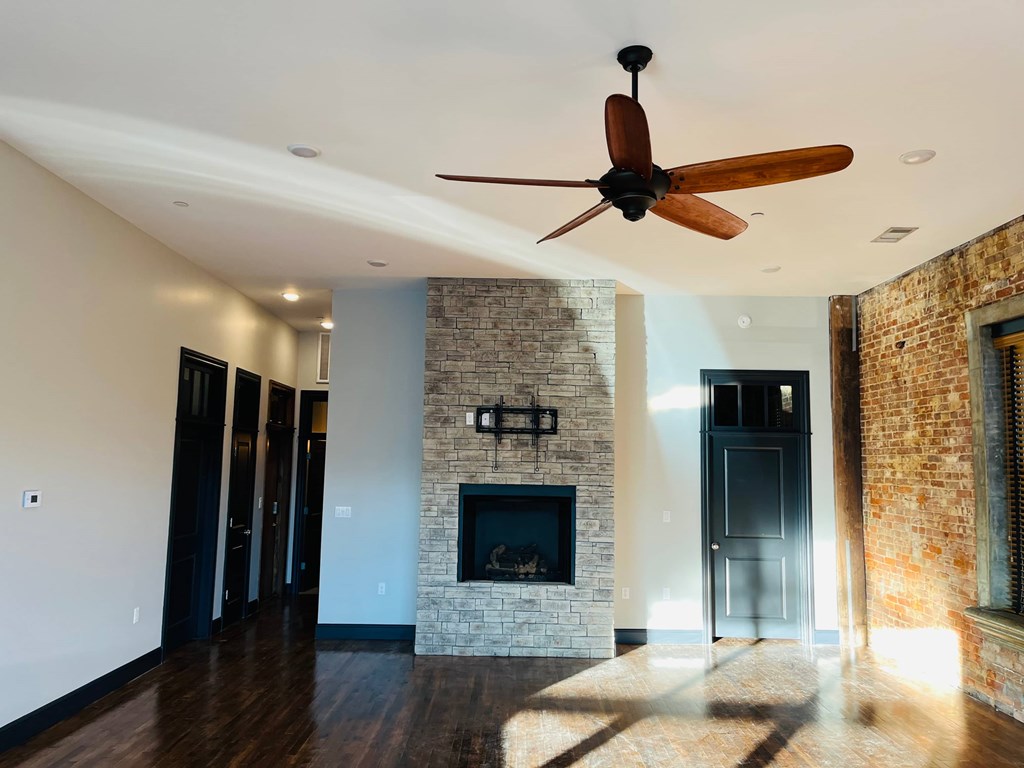 A room with a fireplace and a ceiling fan.