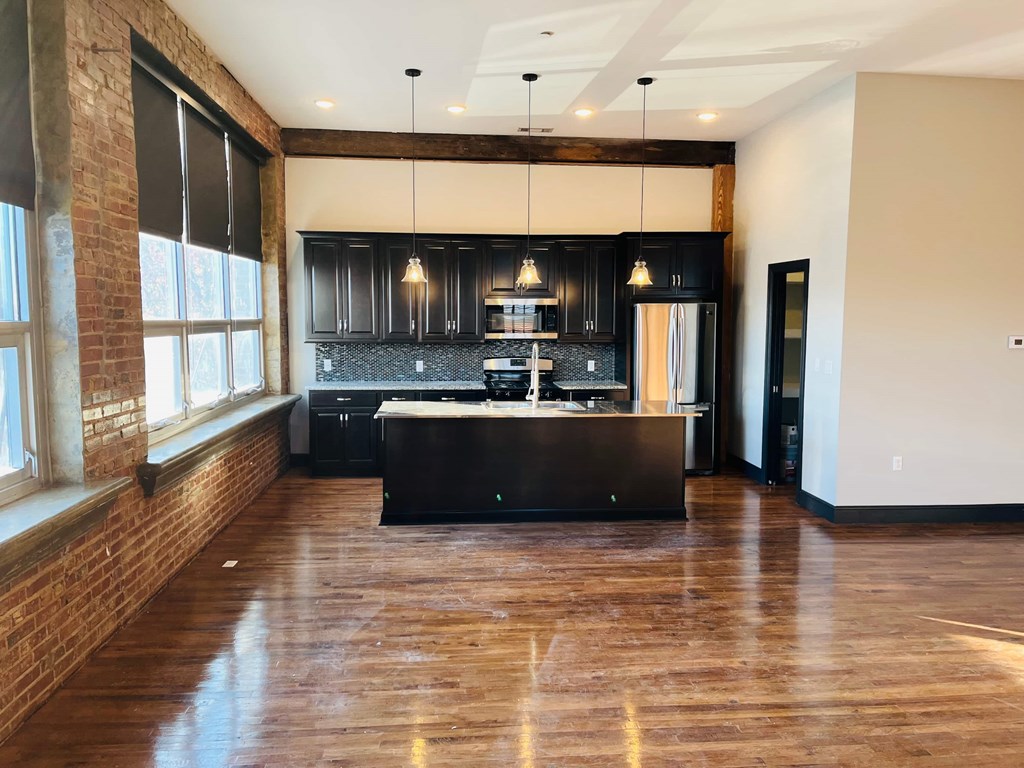 A kitchen with a black countertop and cabinets.