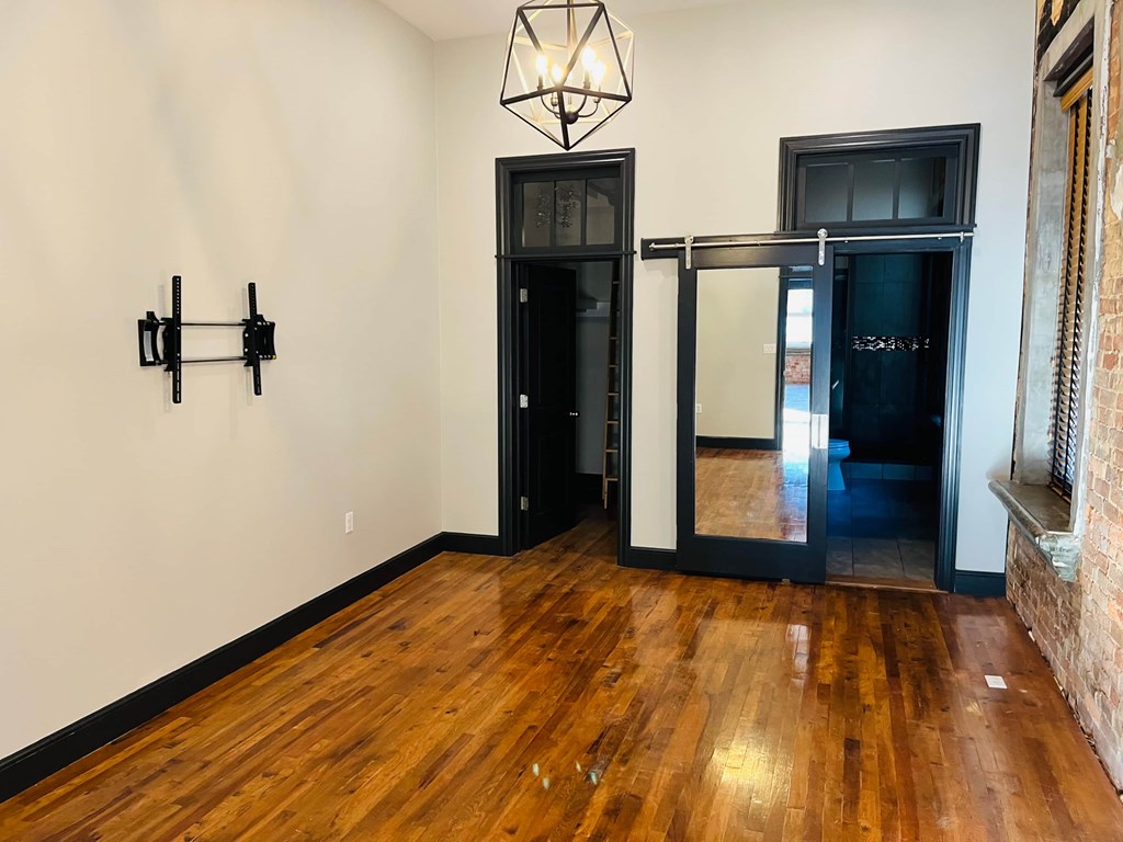 A room with a wooden floor and a black door.