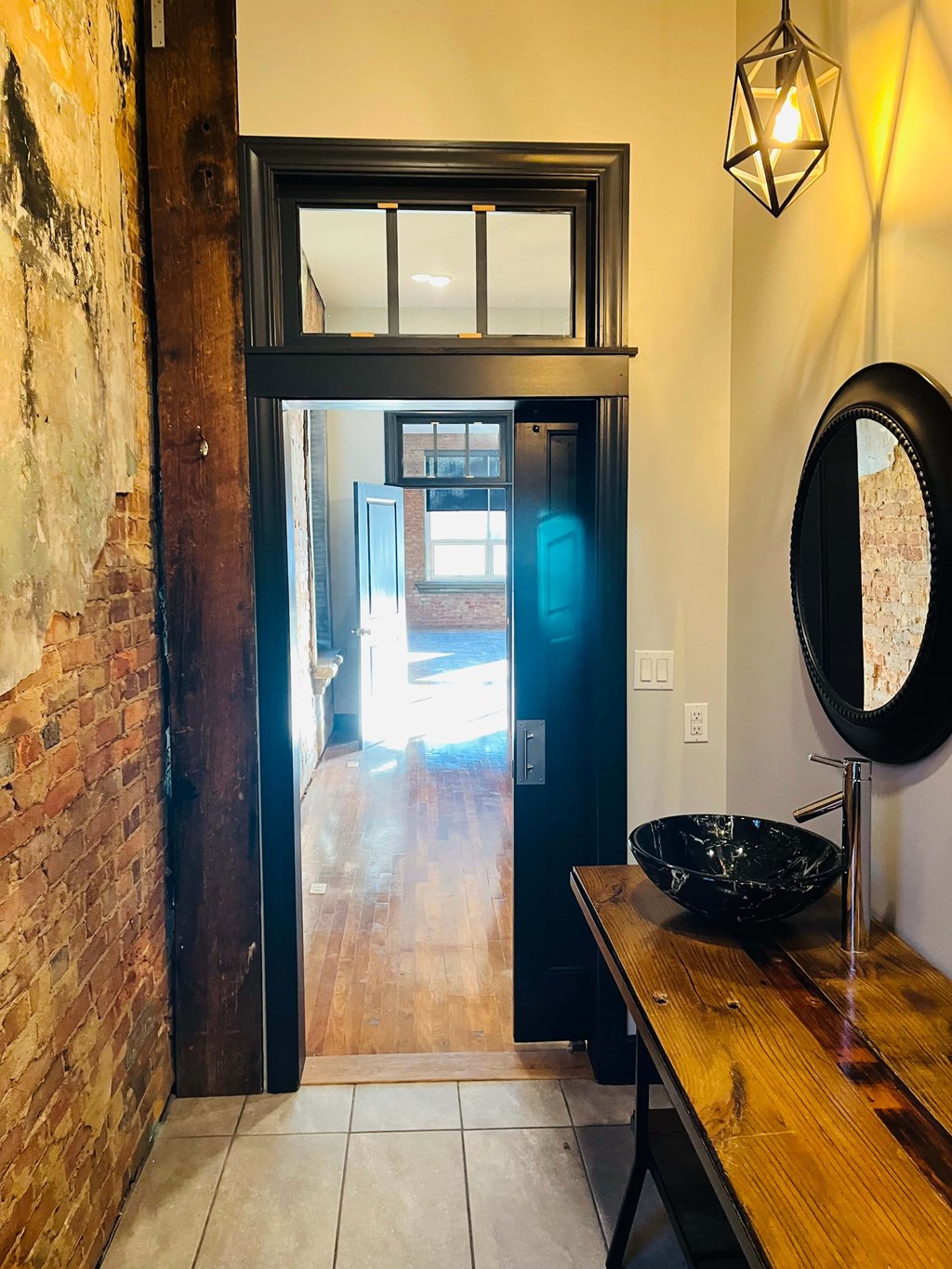 A bathroom with a wooden vanity and a mirror.