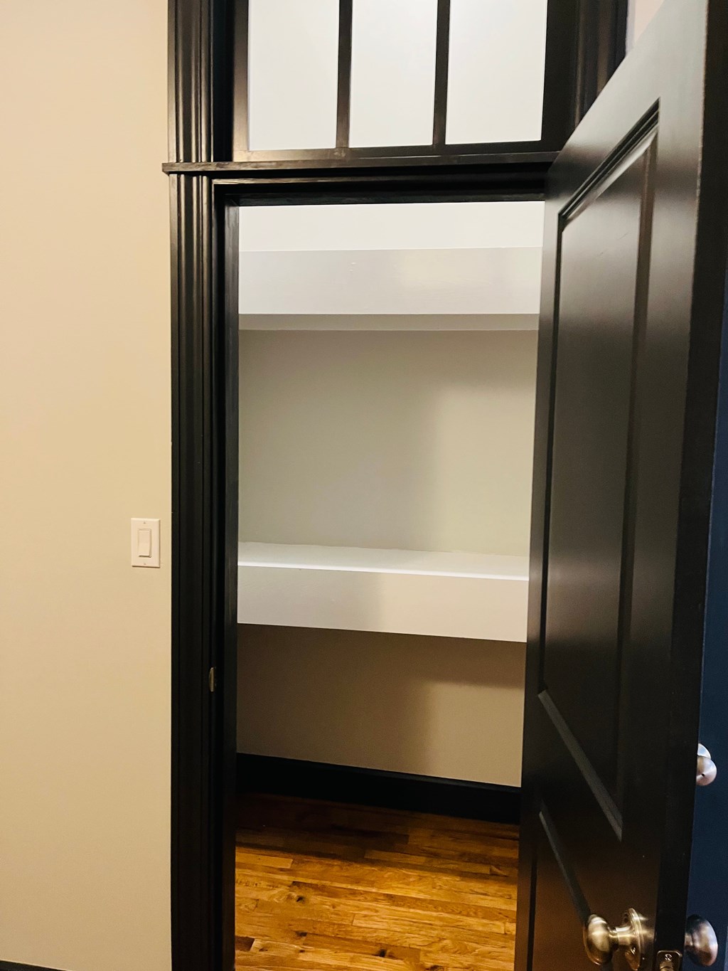 A black door with a glass window and a silver handle.